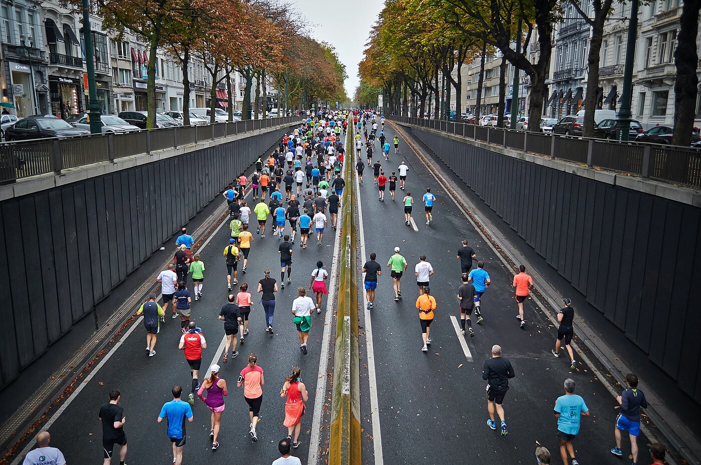Foto einer großen Gruppe Läufer auf einer breiten, städtischen Straße.
